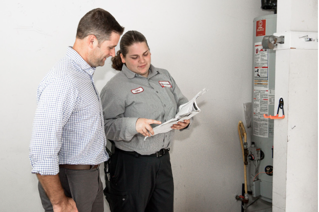 jd service now technician points to water heater manual